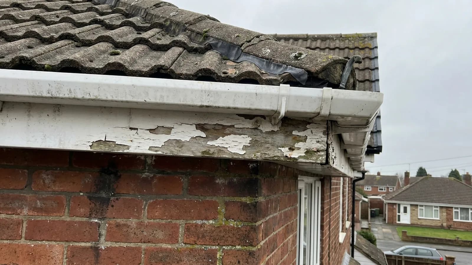 Peeling paint on a wooden fascia board
