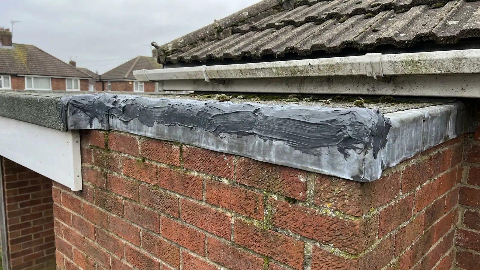 Sealant smeared along the top of a flashing